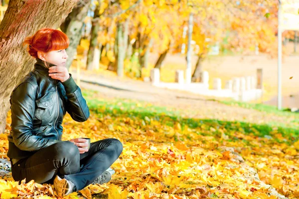 Girl sitting in maple autumn sunny day — Stock Photo, Image