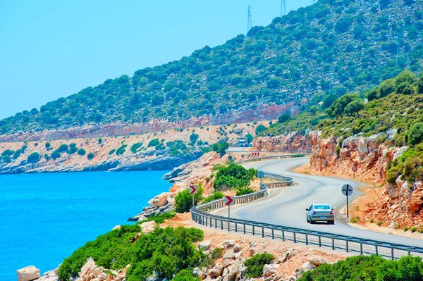 Car driving on mountain road along the sea — Stock Photo, Image