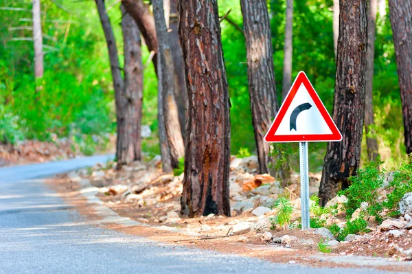 Turn sign on the side of the forest highway — Stock Photo, Image