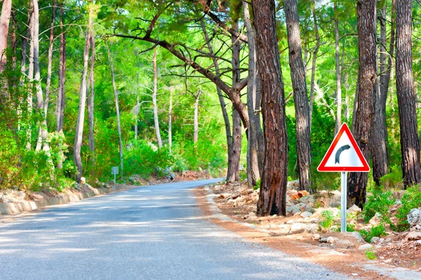 Strada nel bosco e il segno della rotazione — Foto Stock