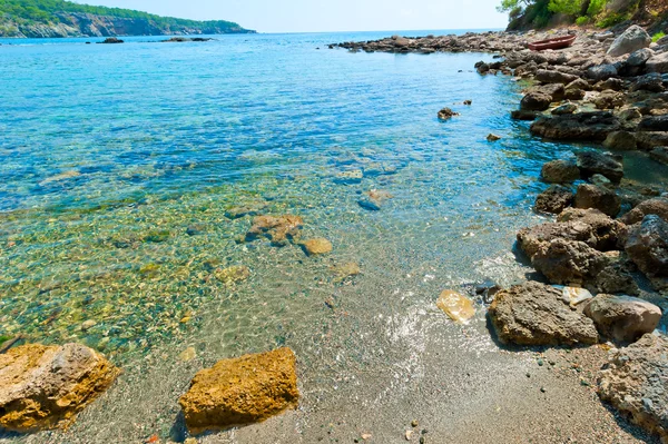 Felsbrocken am Ufer einer sauberen und ruhigen See — Stockfoto