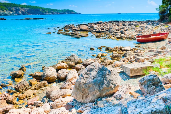 หินขนาดใหญ่บนชายหาดและเรือ — ภาพถ่ายสต็อก