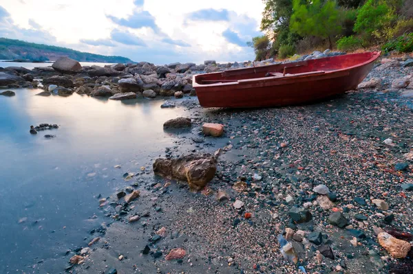 Boat on the rocky shore in the early morning — Stock Photo, Image