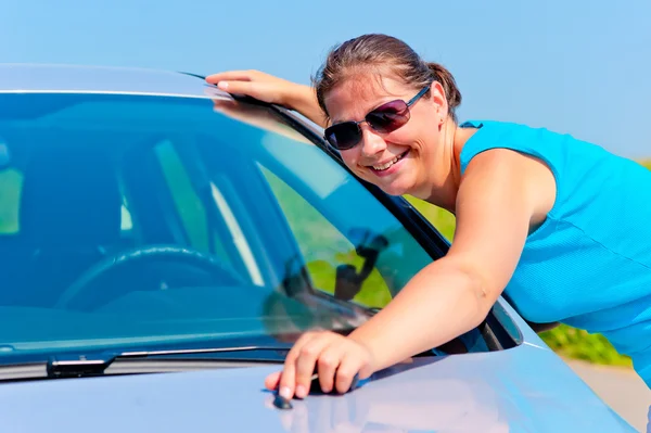 Happy girl embracing his new car — Stock Photo, Image