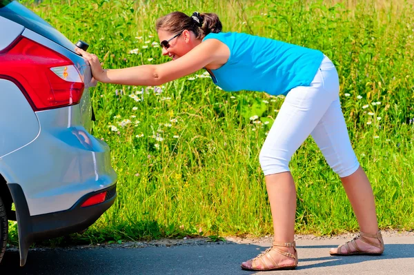 Woman pushing car out of gasoline — Stock Photo, Image