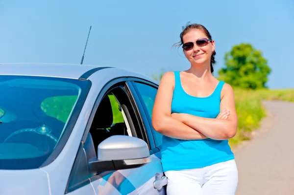 Mujer de pie cerca de su coche en una carretera de campo —  Fotos de Stock