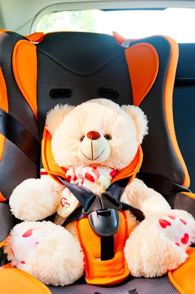 Bear strapped in a child seat in the car — Stock Photo, Image