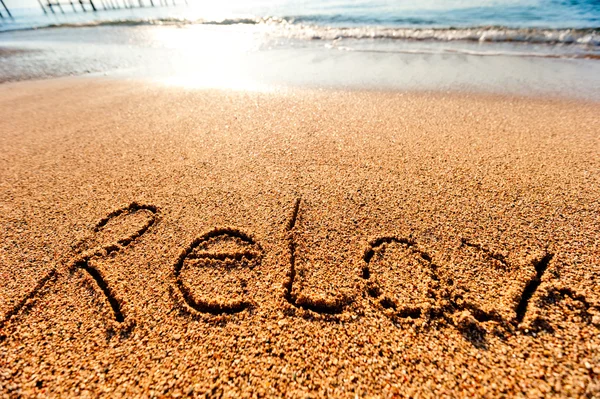 Inschrift Relaxen im Sand am Meer — Stockfoto