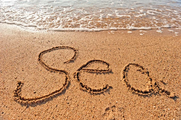 Woord zee geschreven op het zand op het strand — Stockfoto