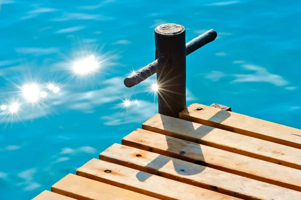 Сонячні промені на морській воді біля дерев'яного пірсу — стокове фото
