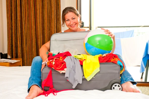 Girl on the bed and a suitcase with things — Stock Photo, Image