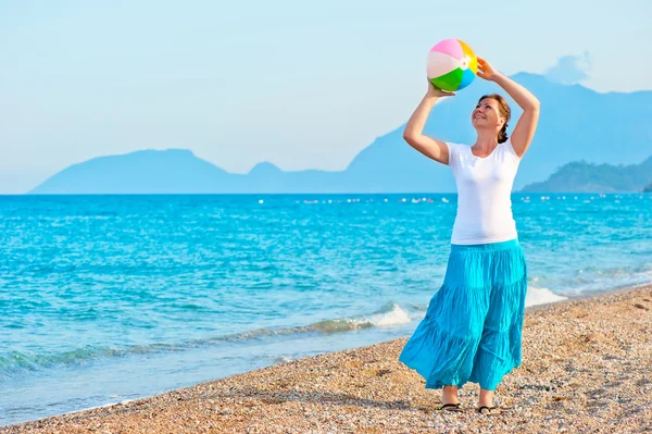 Meisje speelt met een strandbal in de buurt van de zee — Stockfoto