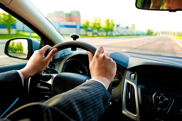 Homem segura o volante firmemente com ambas as mãos — Fotografia de Stock