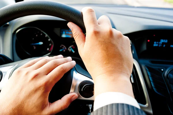 Mão masculina segurando uma roda de carro — Fotografia de Stock