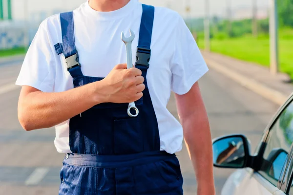 Man in pak mechanic met een moersleutel — Stockfoto