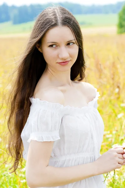 Vacker flicka med långt hår i fältet — Stockfoto