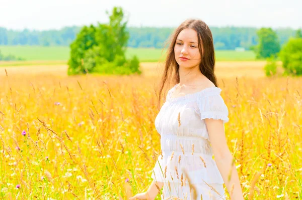 Jeune femme dans le champ de fleurs jaunes — Photo