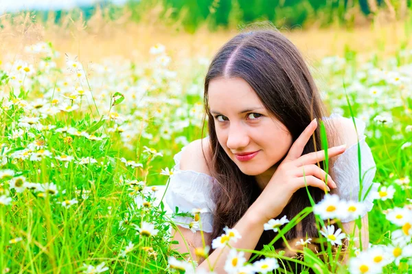 Chicas mirada juguetona en el campo de manzanilla —  Fotos de Stock