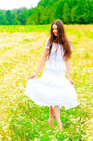 Belleza rusa en un campo rural con flores — Foto de Stock