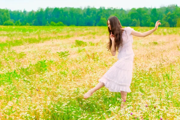 Fiatal balerina, táncol egy mezőt a százszorszépek — Stock Fotó