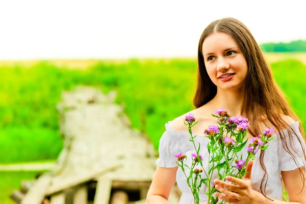 F の背景に花束を持つ美しい少女の肖像画 — ストック写真