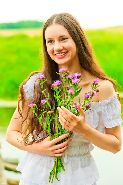 Vackra leende glad tjej med en bukett — Stockfoto