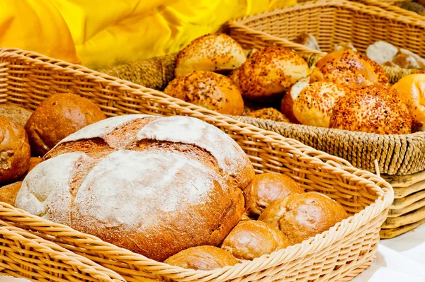 Cesta de mimbre llena de pan y panecillos —  Fotos de Stock