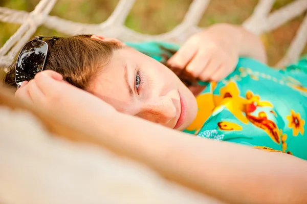 Woman in a turquoise dress resting in a hammock — Stock Photo, Image