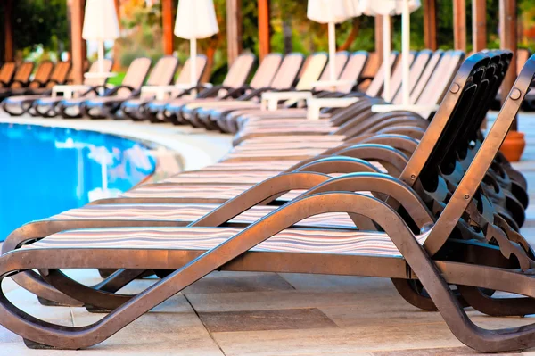 Number of empty sunbeds around the pool in the morning — Stock Photo, Image