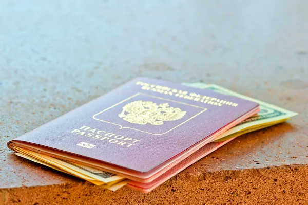 Red passport with dollars on marble surface — Stock Photo, Image