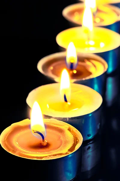 Aantal warme gele kaarsen in het donker — Stockfoto
