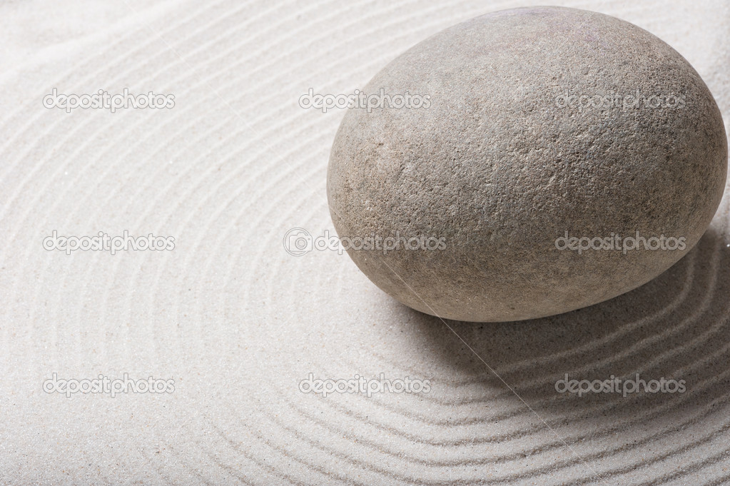 big gray smooth stone on sand