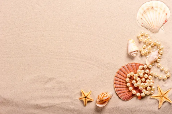 Pearl beads and seashells in the sand — Stock Photo, Image