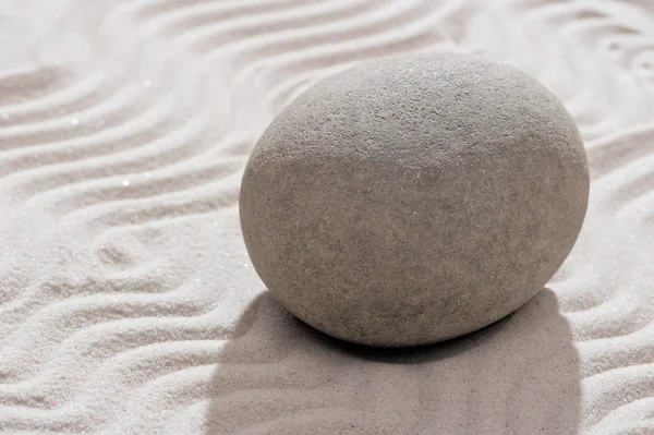 Gray smooth stone in the garden on the sand — Stock Photo, Image