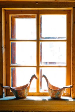 sunlit window Russian huts and carved buckets clipart