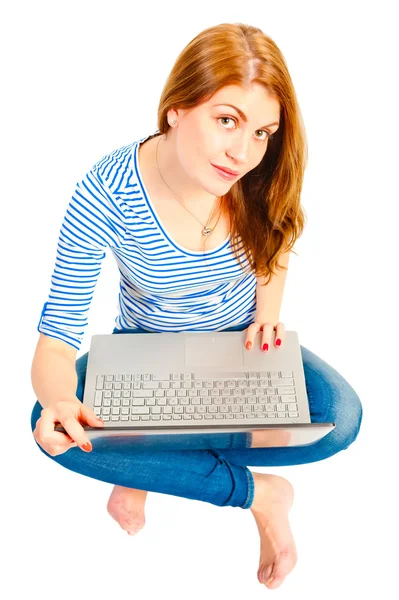 Beyaz bir arka plan ile bir dizüstü bilgisayar üzerinde büyüleyici bir genç kız — Stok fotoğraf