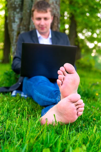 Zaměřit se na bosé nohy na trávníku, podnikatel — Stock fotografie