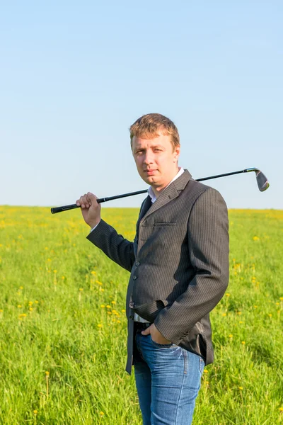 A man in a jacket and jeans going to play golf — Stock Photo, Image