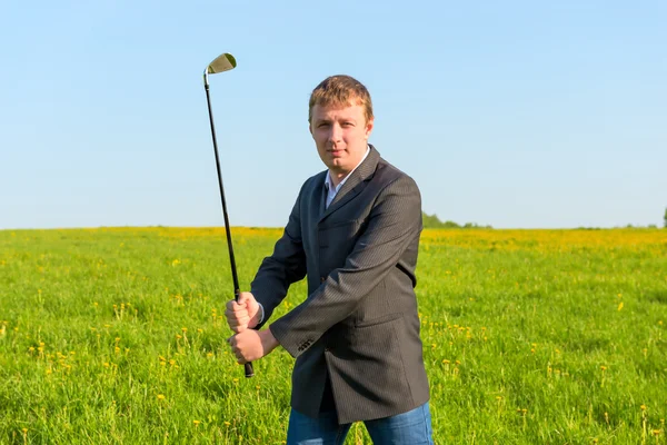 Homem em um terno de negócios segurando um clube de golfe — Fotografia de Stock