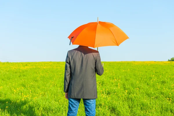 Homme sous un parapluie par une journée ensoleillée dans le domaine — Photo