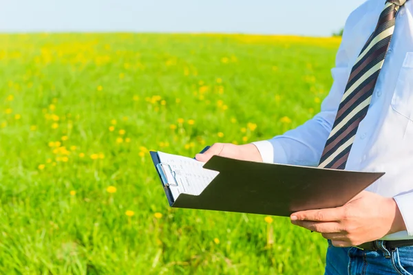 Businessman outdoors reading financial documents — Stock Photo, Image