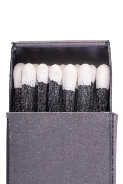 Black matches in a box on a white background macro — Stock Photo, Image