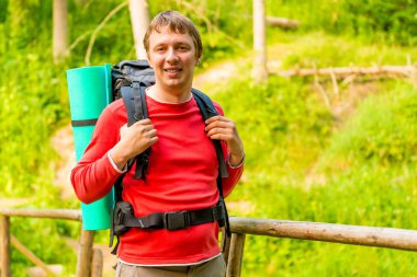 Yaz ormanda hiking bir sırt çantası ile mutlu bir adam