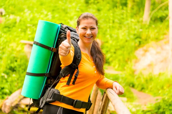 Glad tjej med en ryggsäck i skogen — Stockfoto