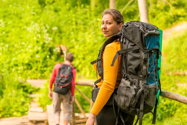 Pareja joven en caminata de verano con mochilas —  Fotos de Stock