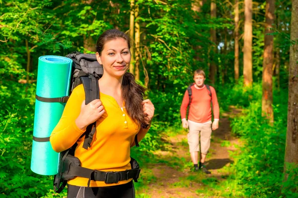 Man och kvinna på morgonen i skogen med ryggsäckar — Stockfoto