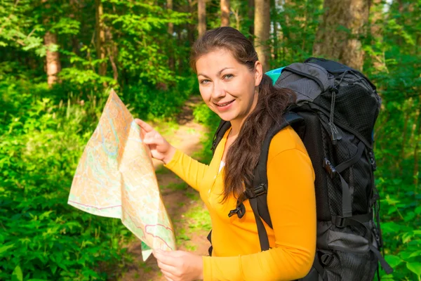 Turist med ryggsäck och karta leende — Stockfoto