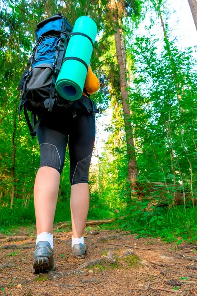 Benen på en kvinna turist med en ryggsäck — Stockfoto