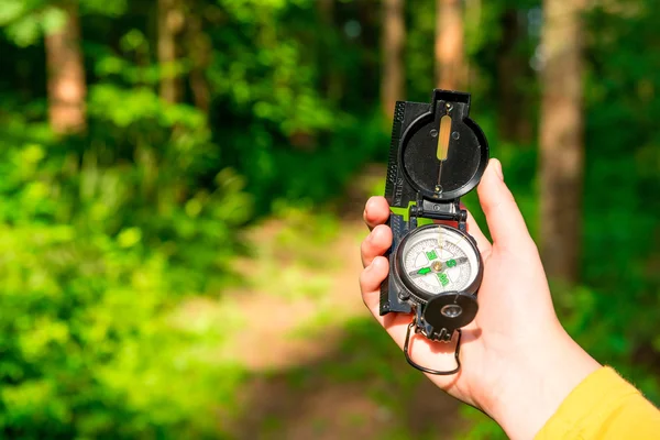 Kompas v ženské ruce, ztratil v lese — Stock fotografie