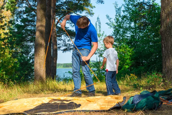 Pai e filho definir a tenda no lago — Fotografia de Stock